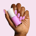 Hand with nails painted Fierce & Loving lilac gel polish holding matching bottle by Olive and June for long-lasting mani