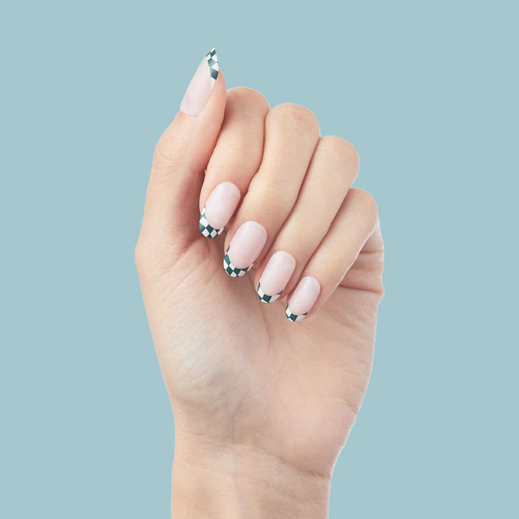 Checkerboard French - Press-On | Short | Round hand with short round false nails featuring black and white checkered French tips on nude base