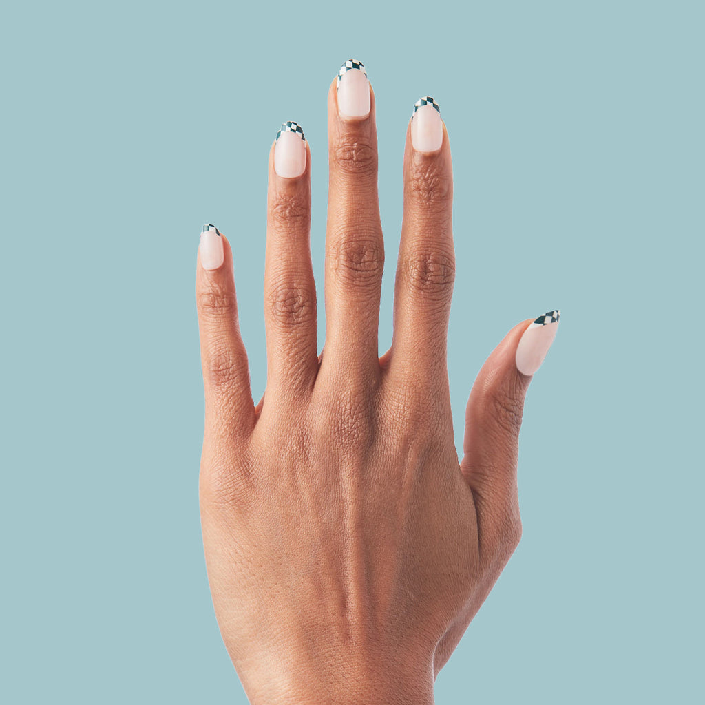 Checkerboard French - Press-On | Short | Round hand displaying short round false nails with checkered tips on nude base