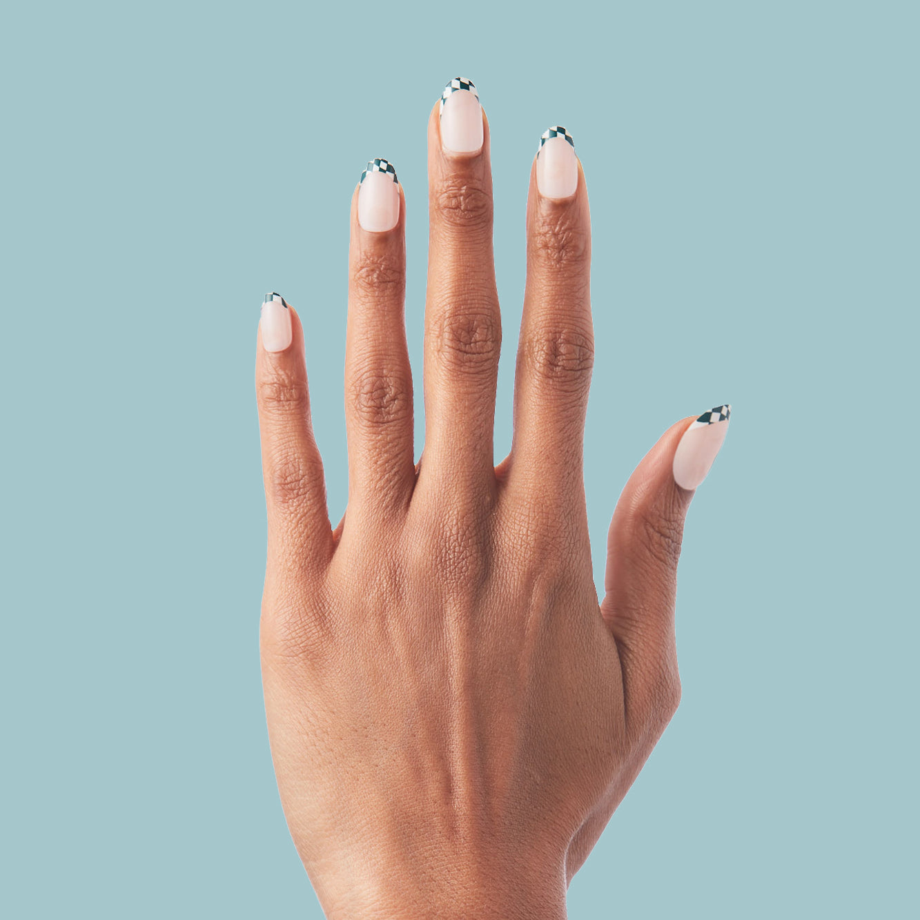 Checkerboard French - Press-On | Short | Round hand displaying short round false nails with checkered tips on nude base