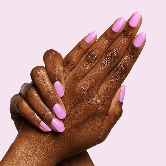Hands with nails painted in Fierce & Loving lilac gel polish showing a smooth, long-lasting manicure by Olive and June