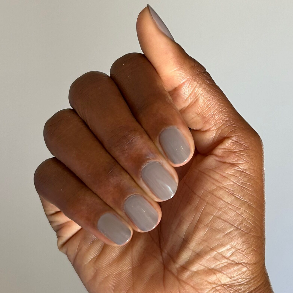 Hand with smooth nails painted in AW - Gel warm grey polish for a chic and durable manicure on natural skin tone