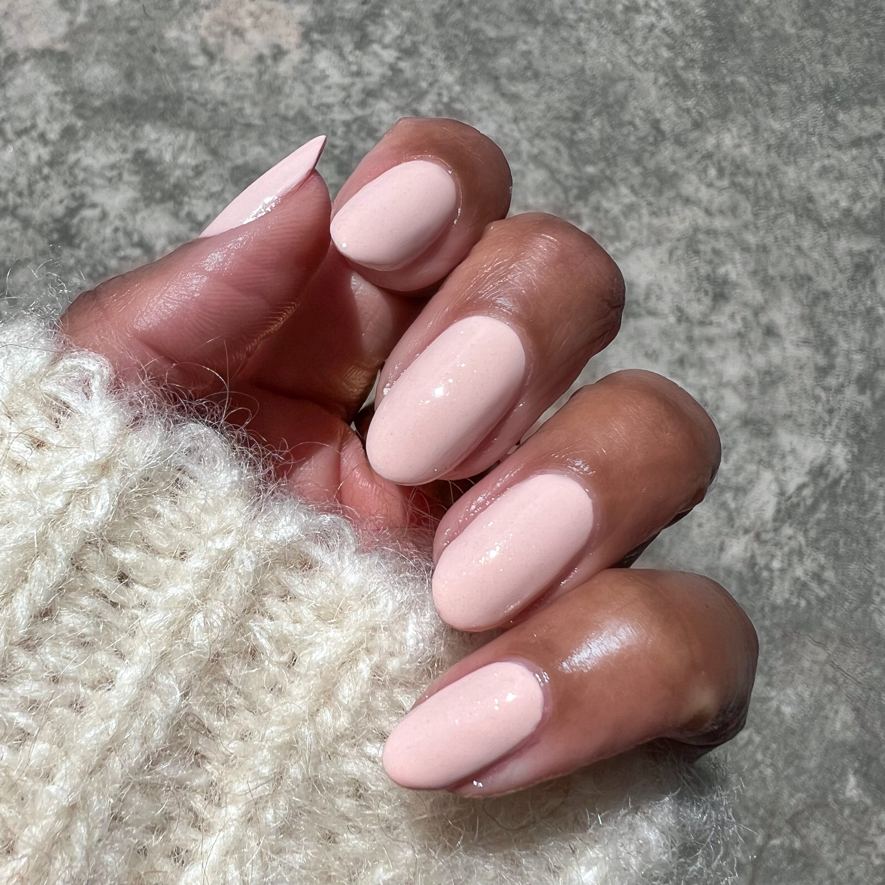 hand with almond-shaped nails painted in cold foam pls soft shimmer neutral beige polish for polished mani