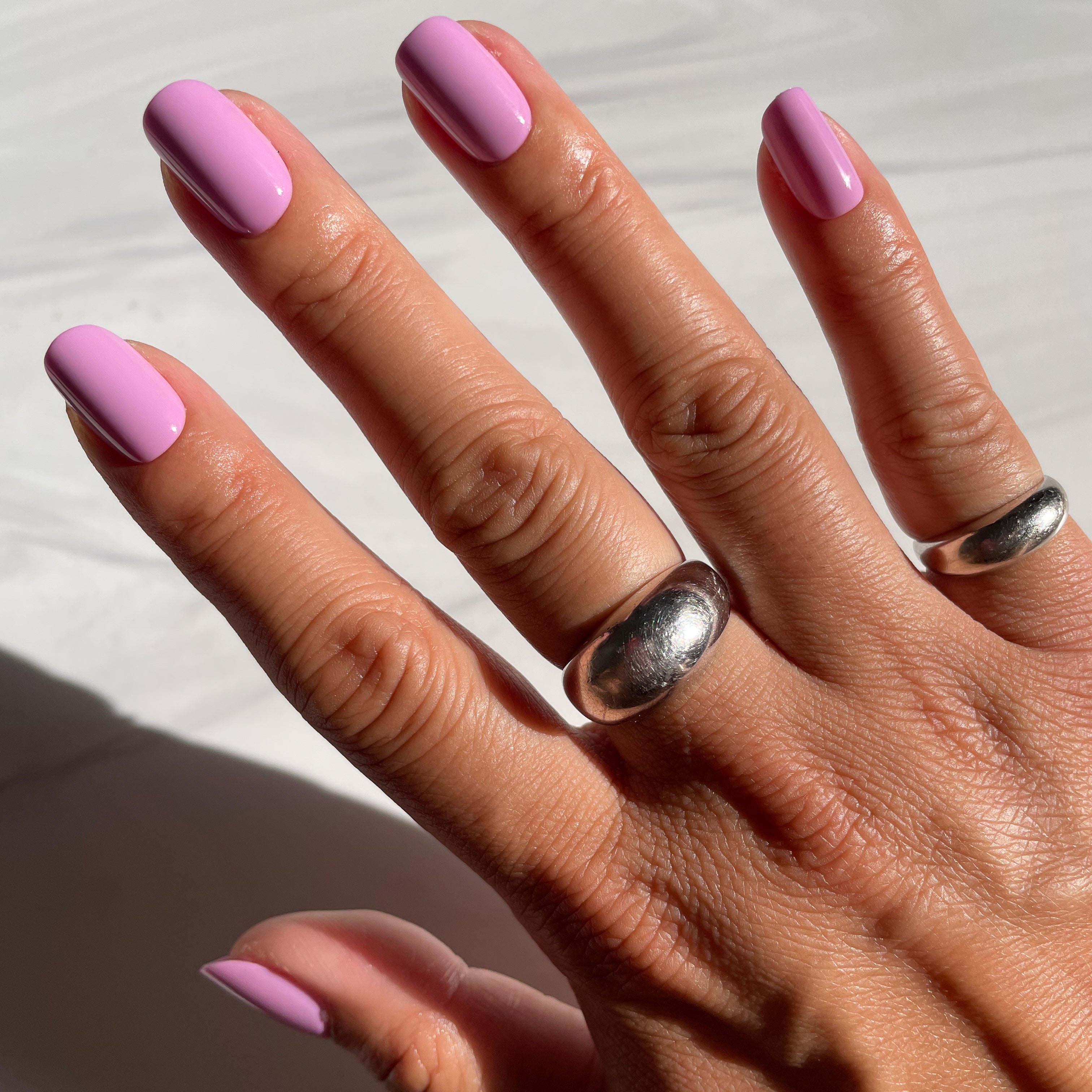 Hand with Fierce & Loving | Squoval | Short lilac short squoval press-on nails and silver rings in natural light