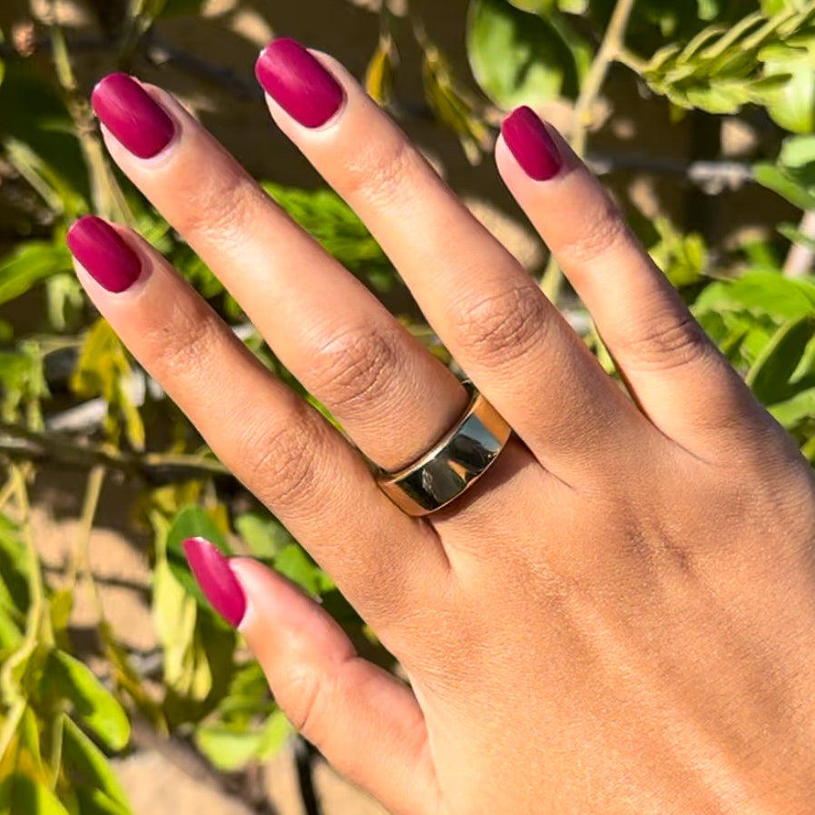 Mulberry | Extra Short | Squoval - Tab Press-On showcasing deep mulberry maroon press-on nails on hand outdoors with gold ring