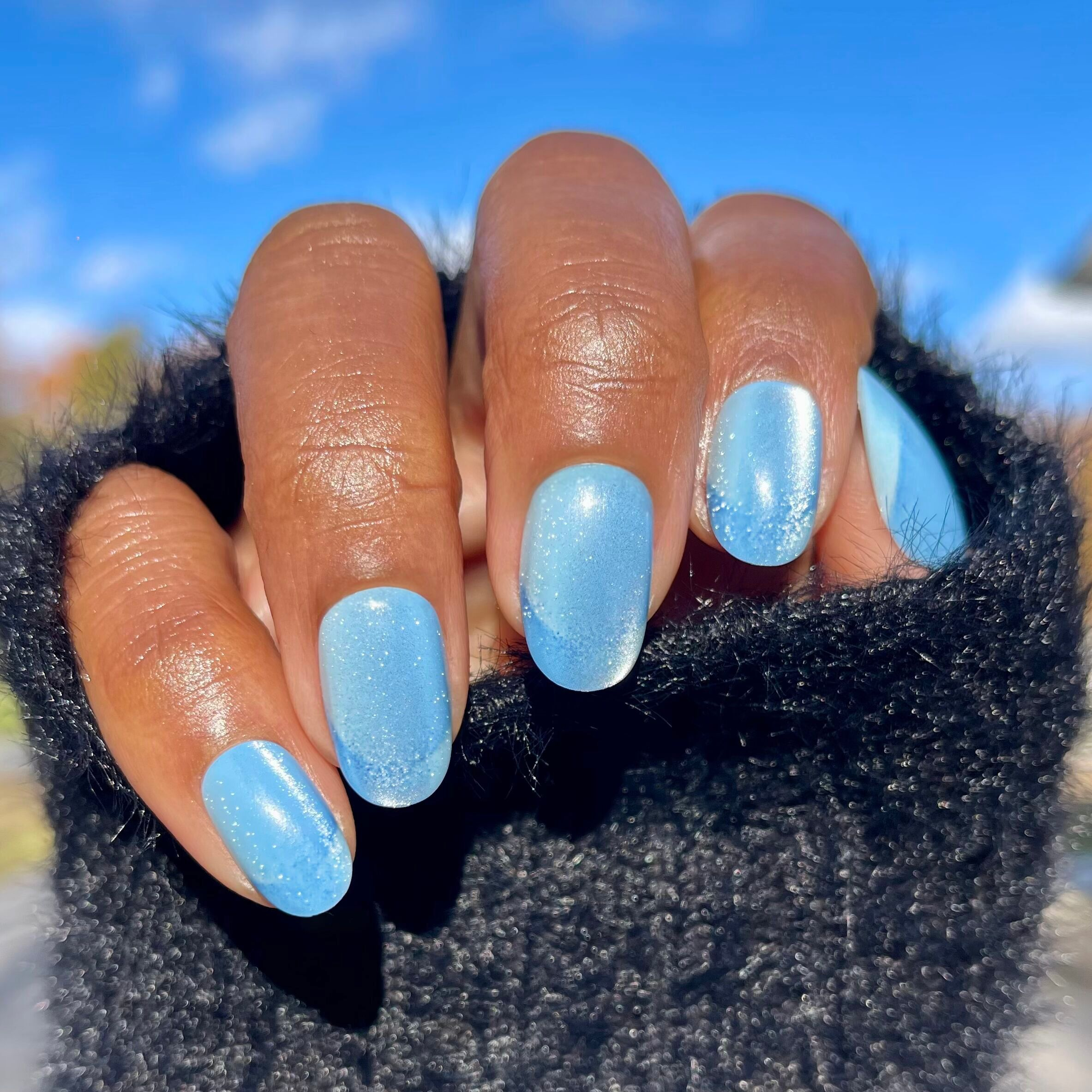 Axolotl Velvet Illusion French - Press-On | Short | Round showing shimmering blue velvet false nails with subtle French tip design outdoors