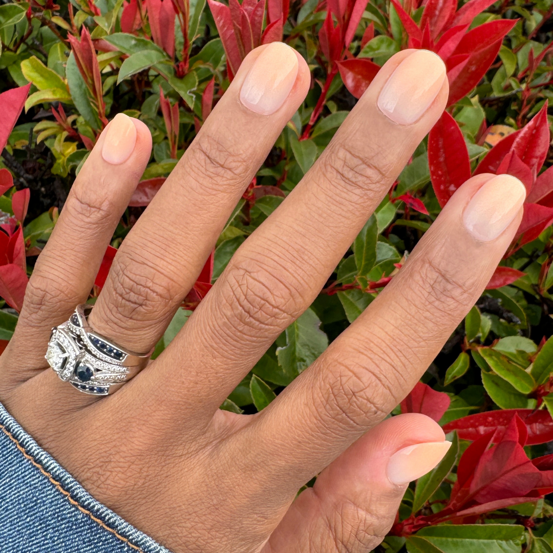 BI Syrup Gradient - Press-On | Extra Short | Round showing hand with extra short round nails in peachy pastel gradient manicure outdoors