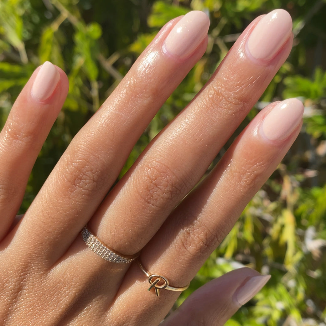 hand with smooth nails painted in shimmery neutral beige cold foam pls polish for natural-looking manicure