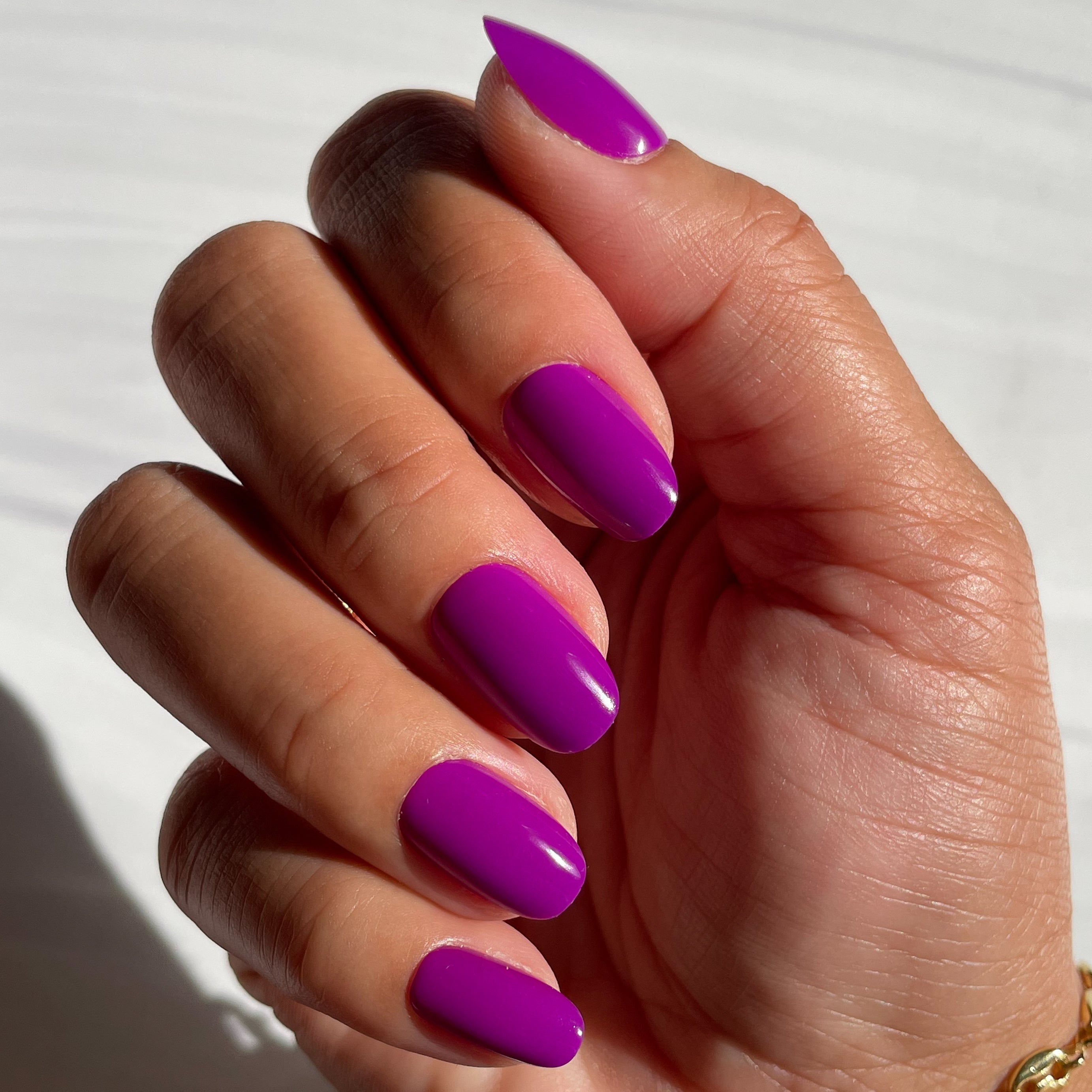Grape Soda | Round | Short press-on nails in bright pop purple with smooth glossy finish shown on hand in natural light