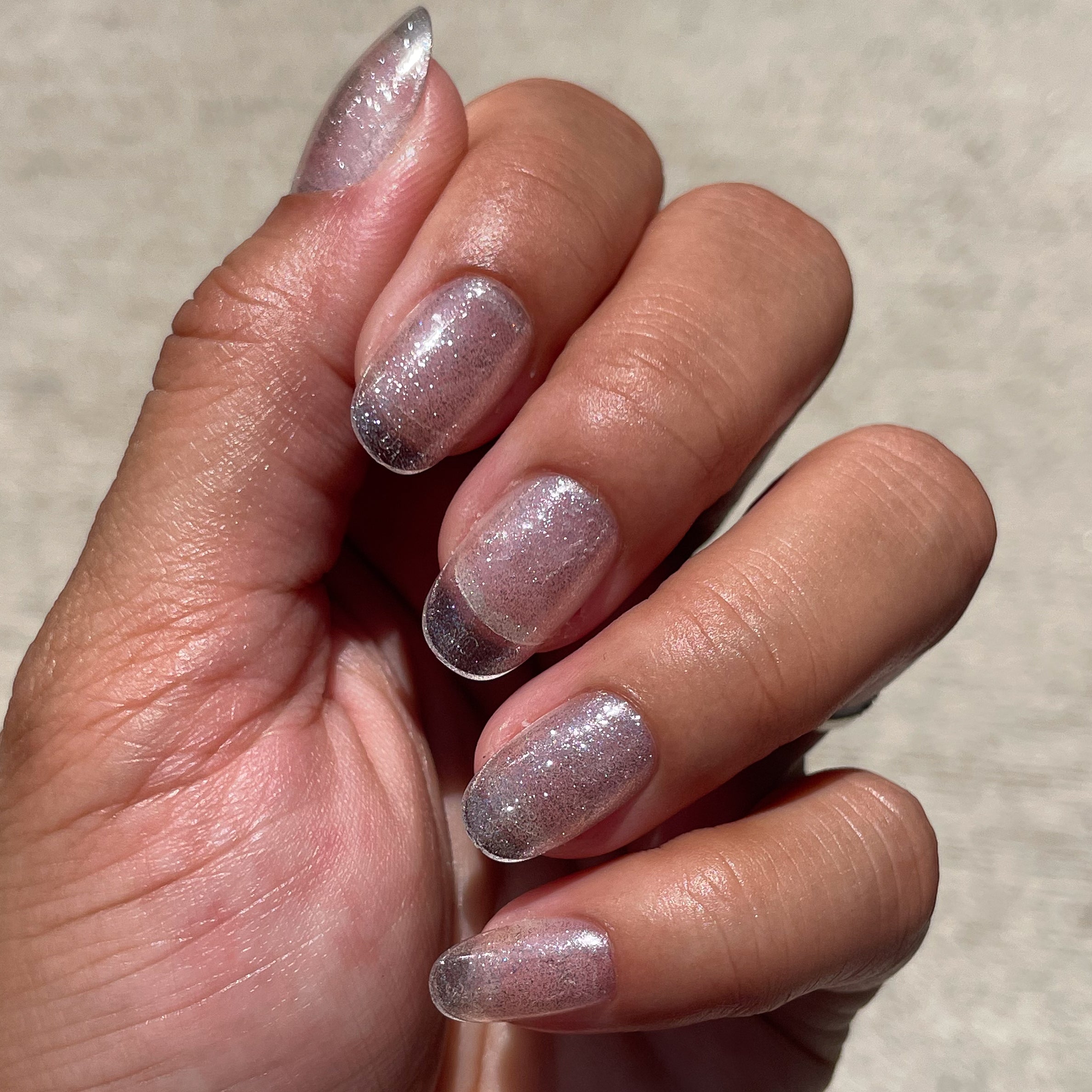 Pure Glitter - Press-On | Short | Round showing short round false nails with silver glitter polish for an easy at-home mani