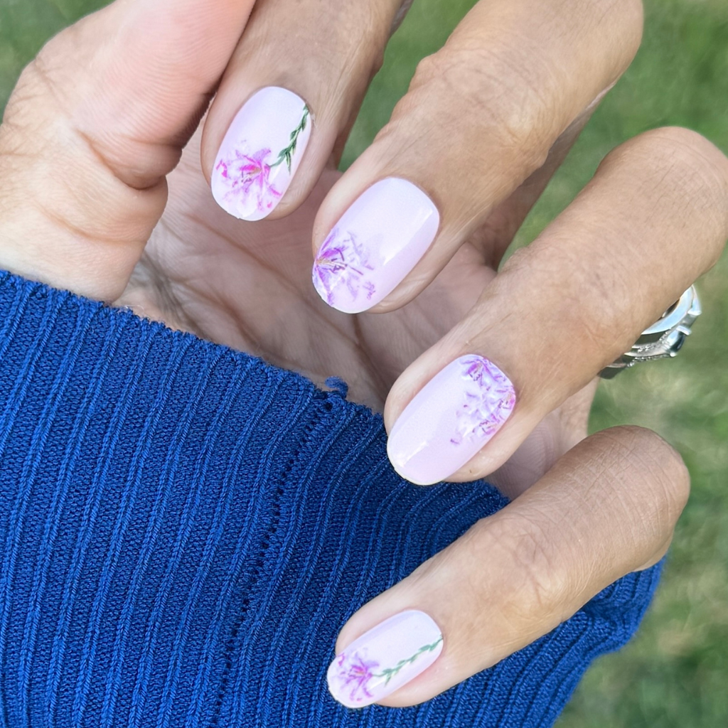 Blooming Lily - Press-On | Short | Round showing hand with short round pale pink nails and delicate shattered lily floral design manicure