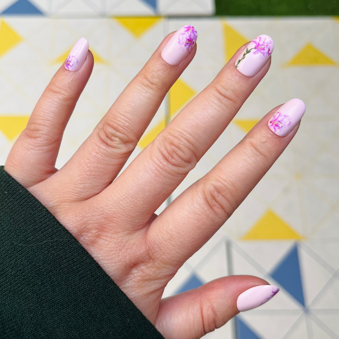 Blooming Lily - Press-On | Short | Round showing hand with pale pink short round nails and delicate purple floral press-on manicure