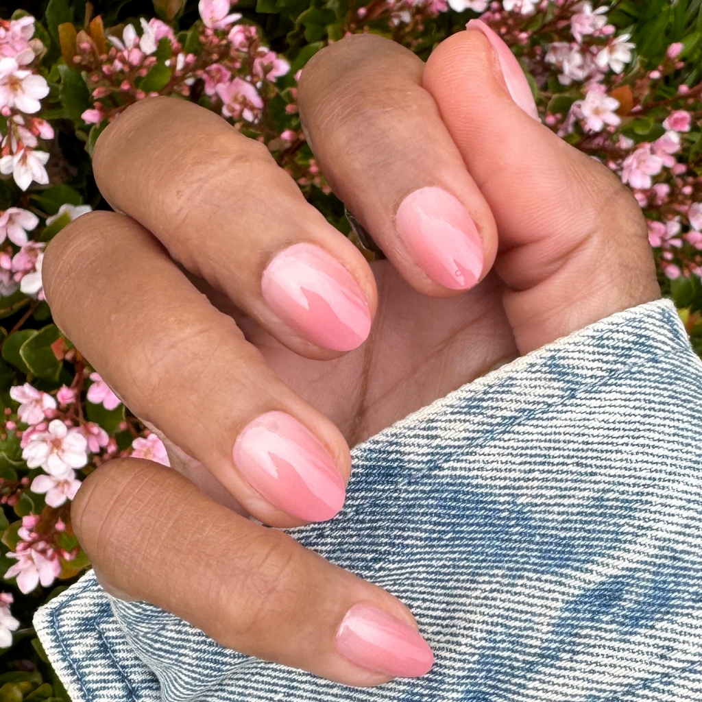 Blush Syrup Gradient - Press-On | Short | Almond showing hand with short almond warm blush gradient press-on manicure outdoors
