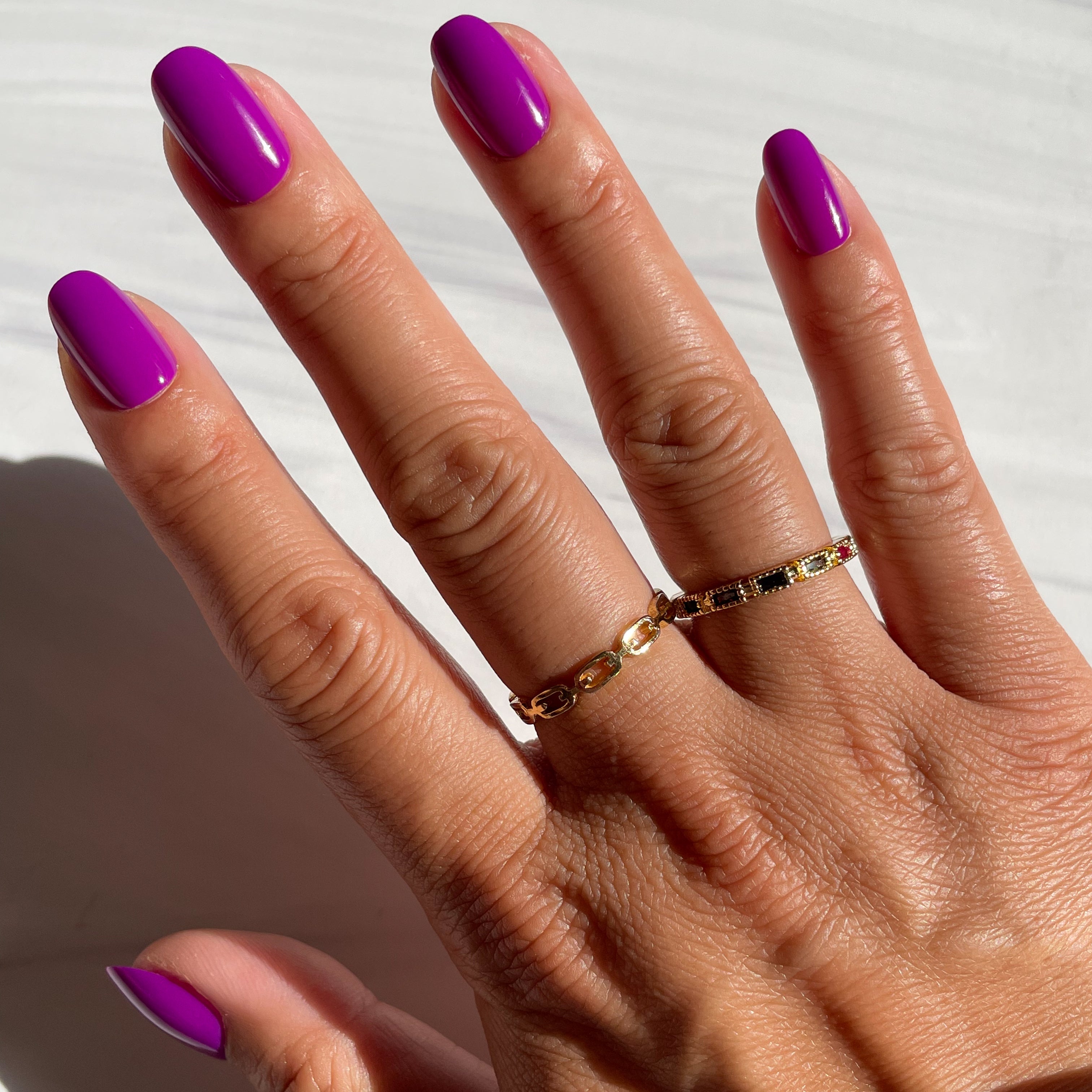Grape Soda | Round | Short vibrant purple press-on nails in short round shape with glossy finish shown on hand in sunlight