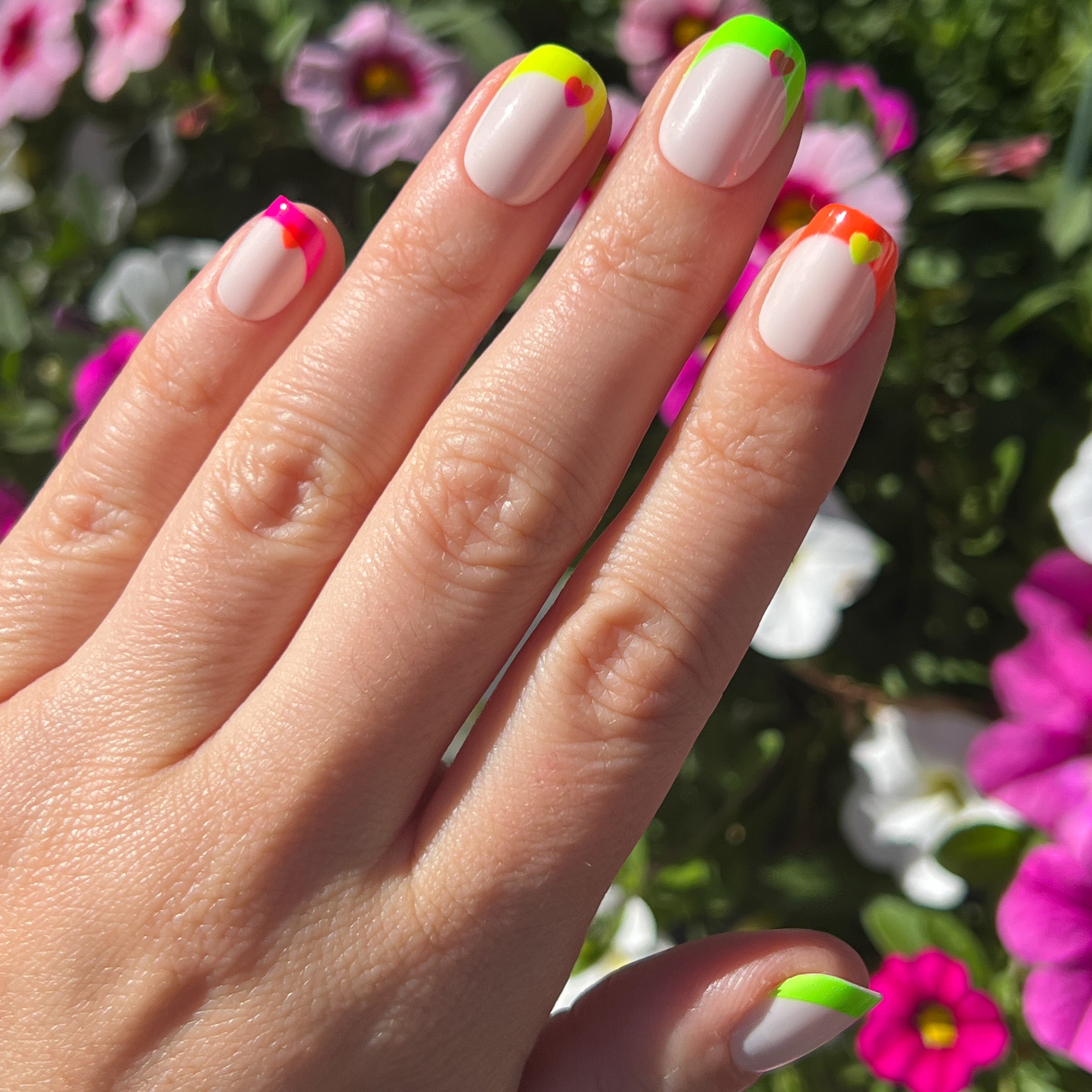 Neon Heart French | Squoval | Extra Short press-on nails with neutral base, neon tips, and bright heart accents for a fresh mani