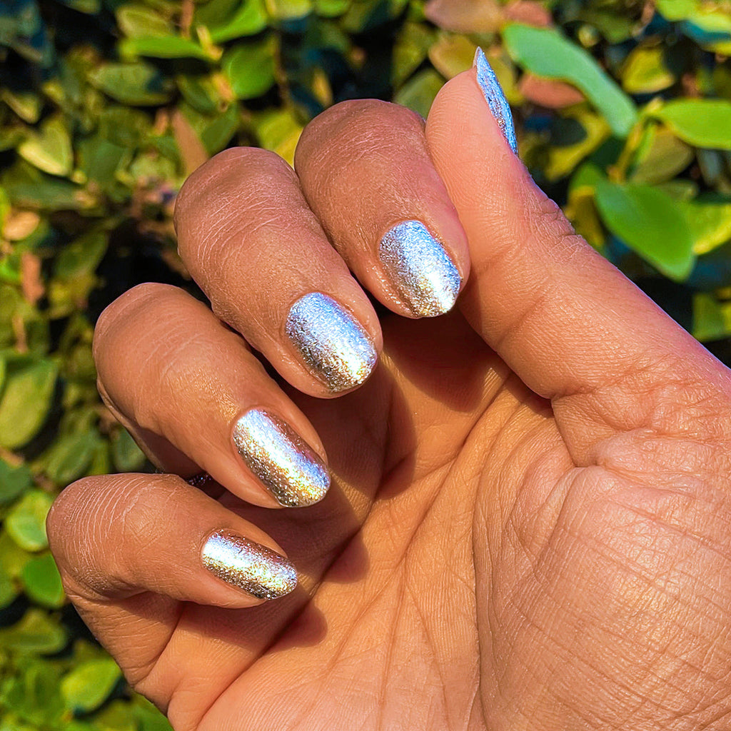 Candy Wrapper crushed metallic silver gel polish on nails with a shimmering quick dry manicure in natural light outdoors