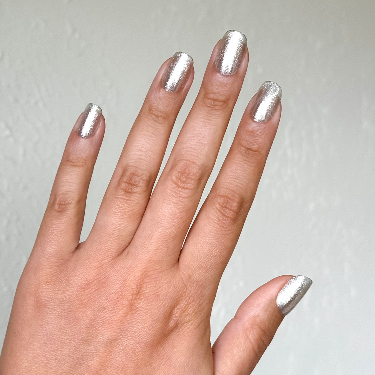 Hand displaying Candy Wrapper - Press-On | Short | Squoval metallic silver crushed foil shimmer false nails manicure