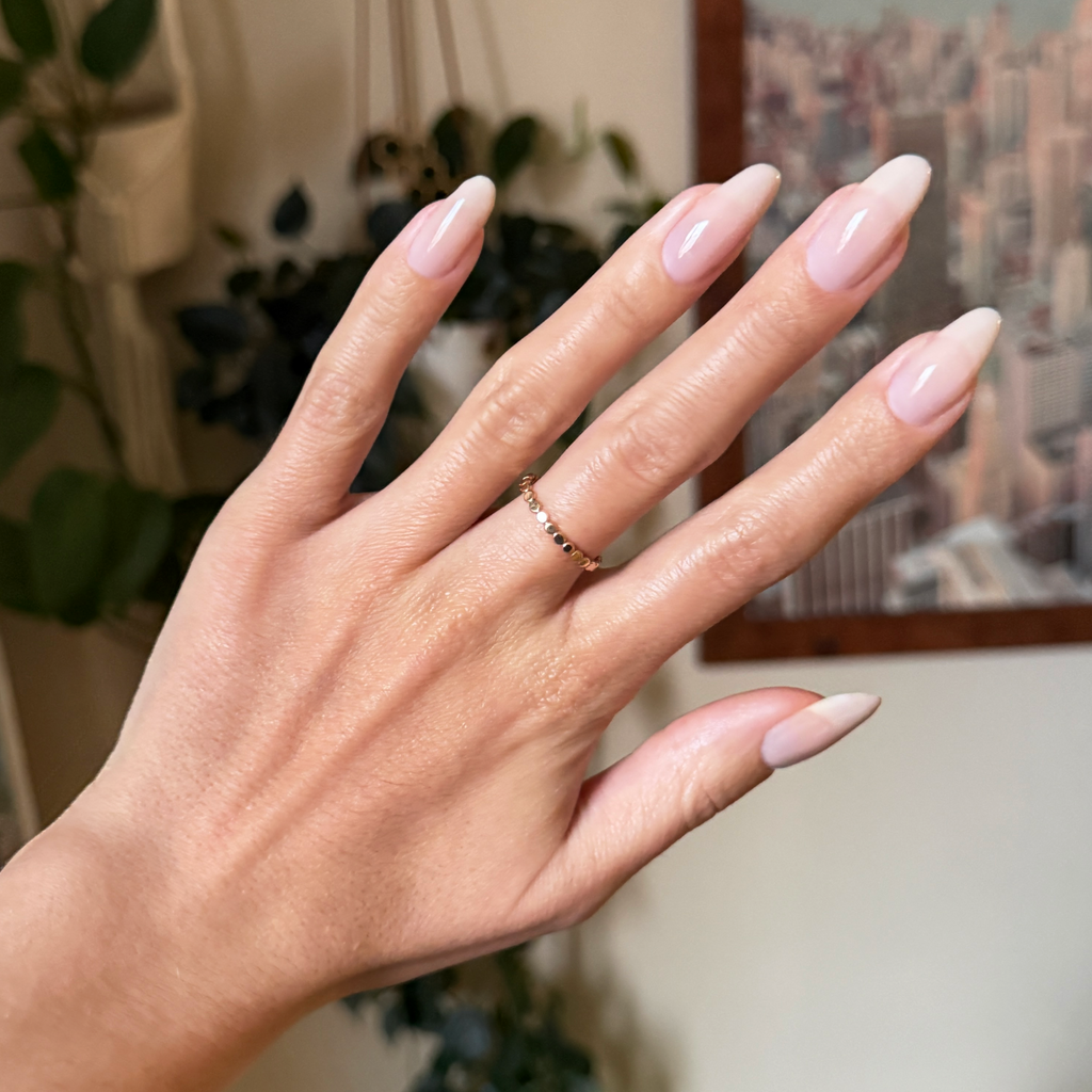Cashmere Kiss - Builder Gel on almond-shaped nails with smooth, sheer soft greige manicure in indoor setting