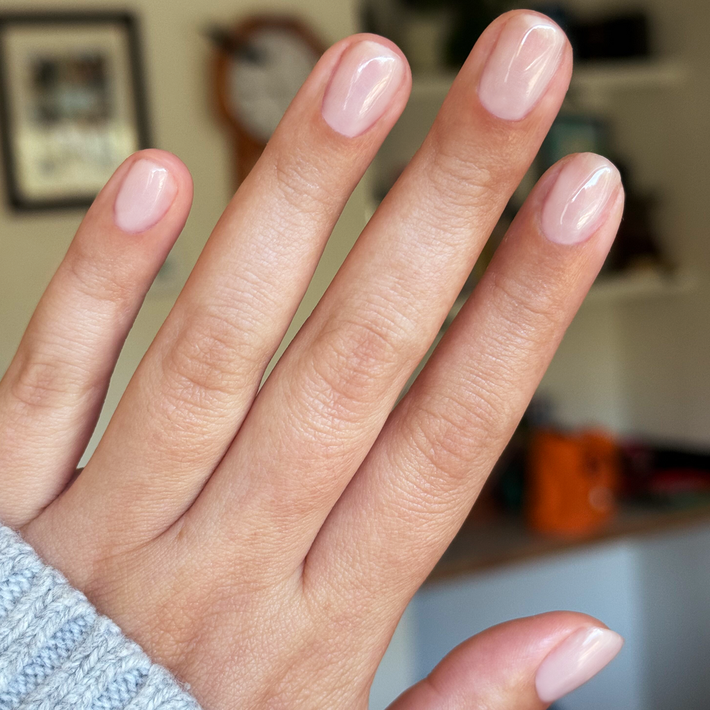 Cashmere Kiss - Builder Gel on natural nails with sheer greige polish and glossy finish in cozy indoor setting