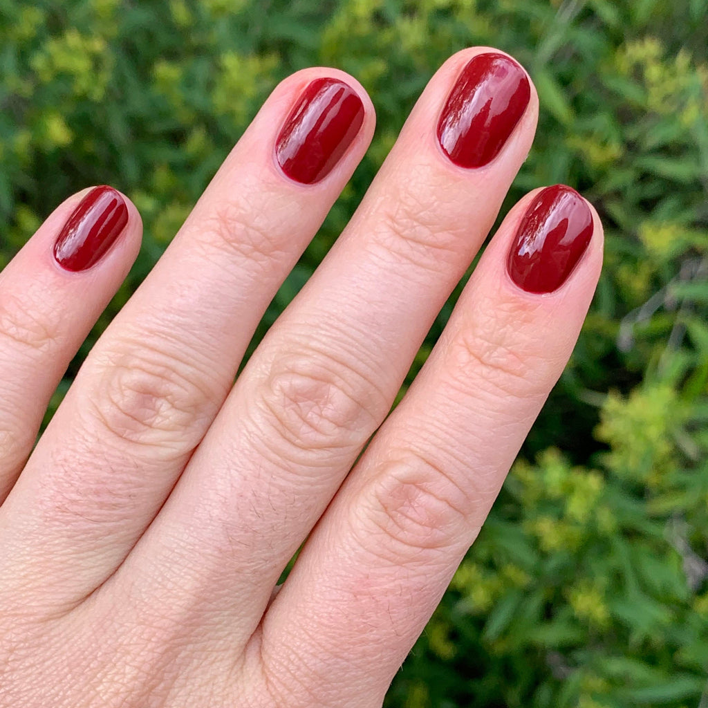Fingers with shiny nails painted in Olive and June Cozy Up polish for a warm and polished mani look at home