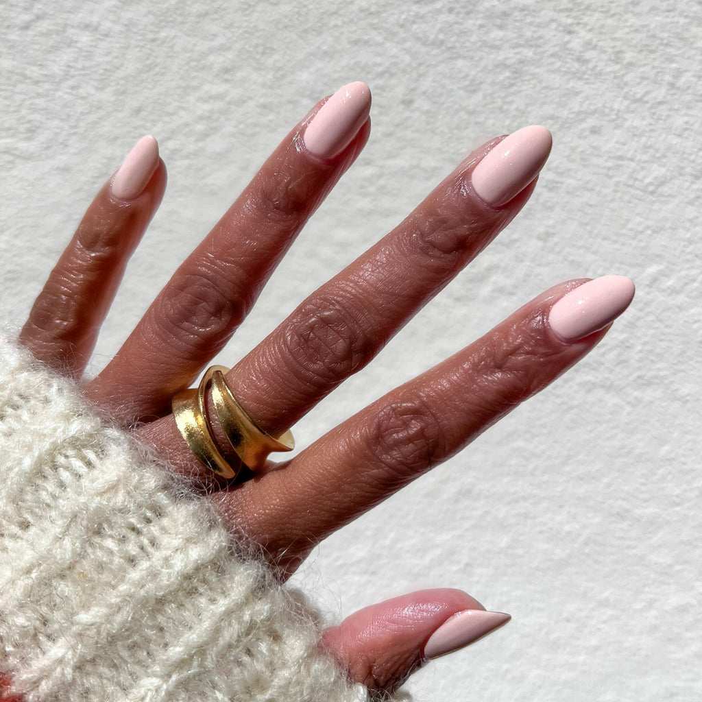 hand with smooth nails painted in soft neutral beige cold foam pls polish for a clean, natural manicure look