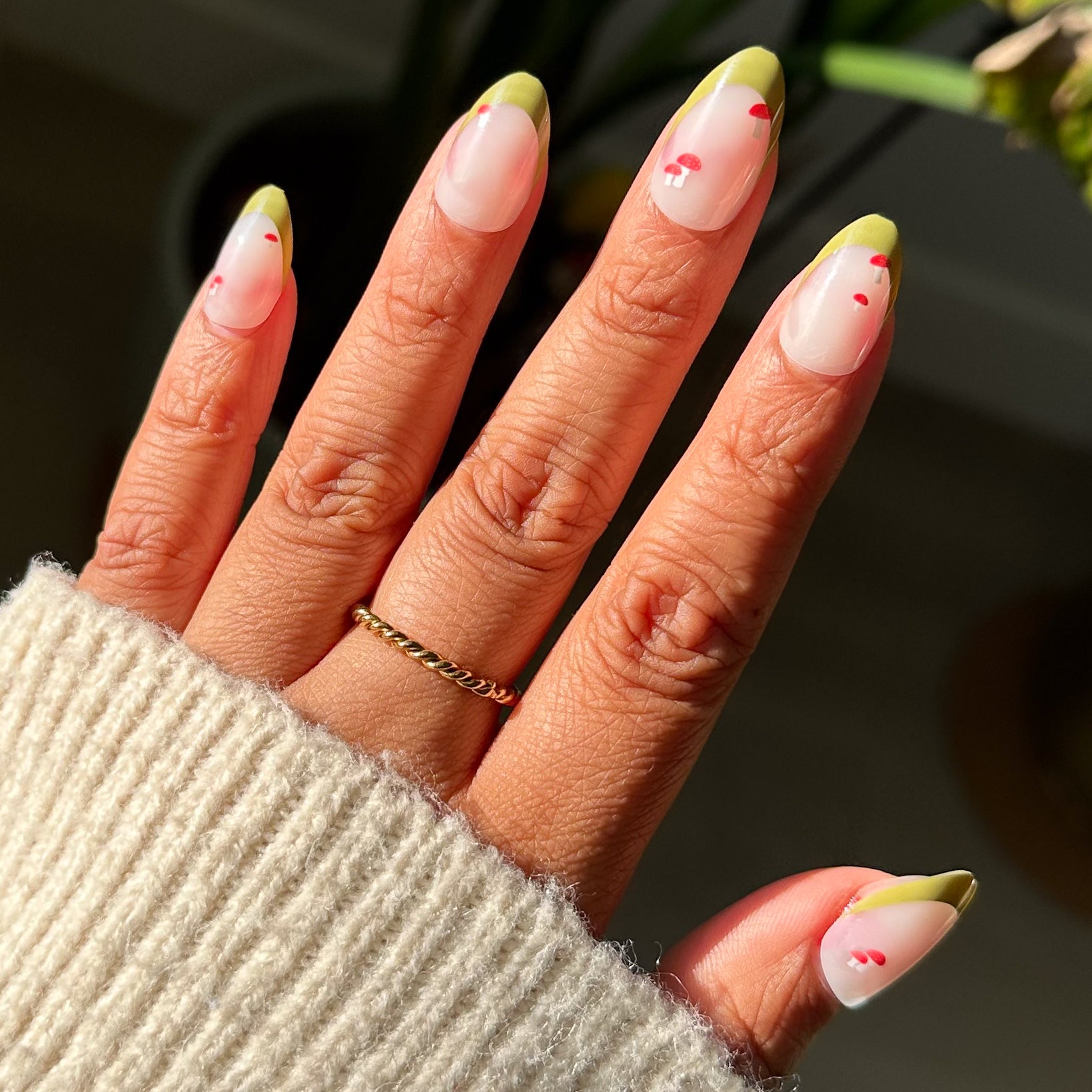 Mushroom Fall French - Press-On | Medium | Almond nails with olive tips and small red mushroom designs on hand in sunlight