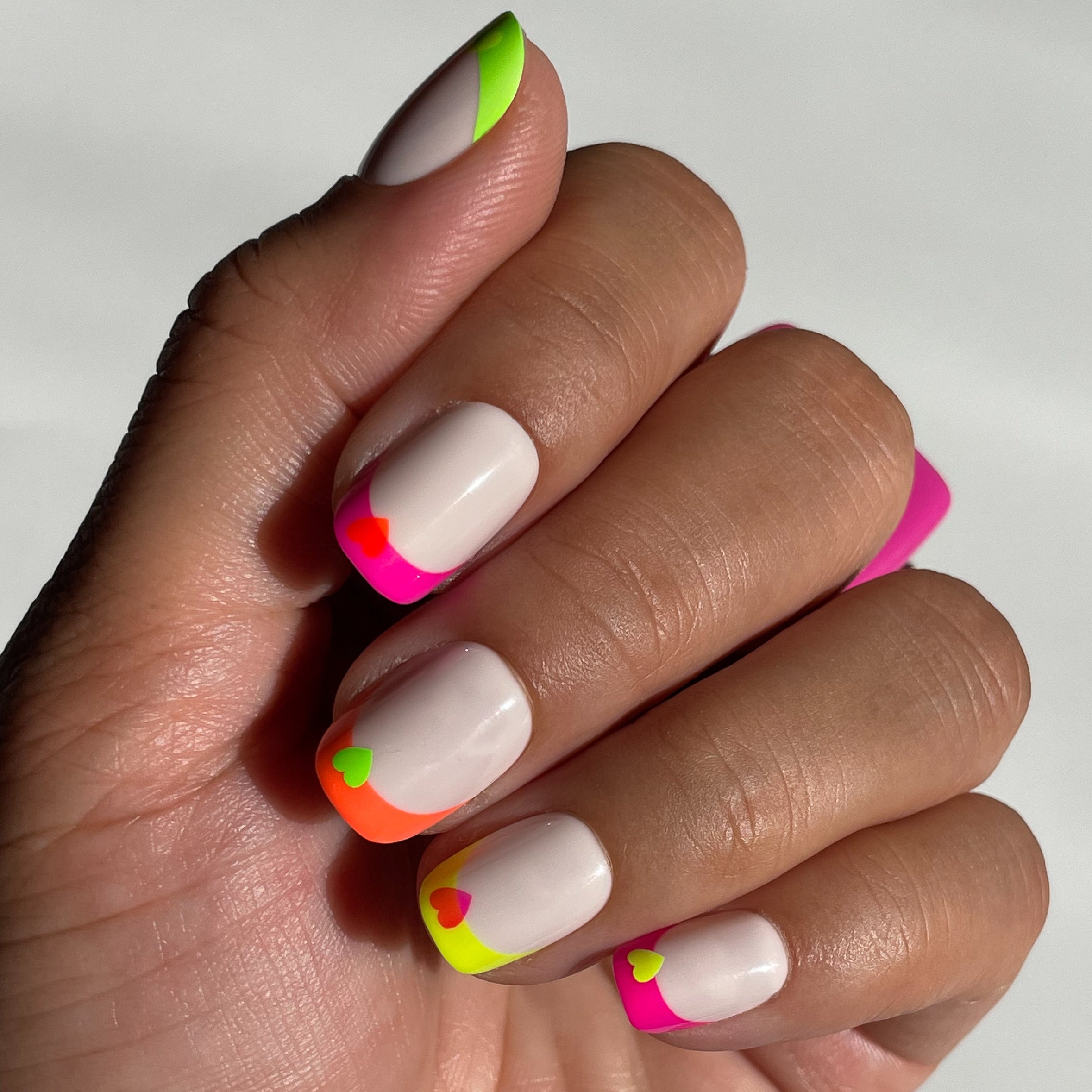 Neon Heart French | Squoval | Extra Short press-on nails with neutral base, neon tips, and contrasting heart accents for a bright mani