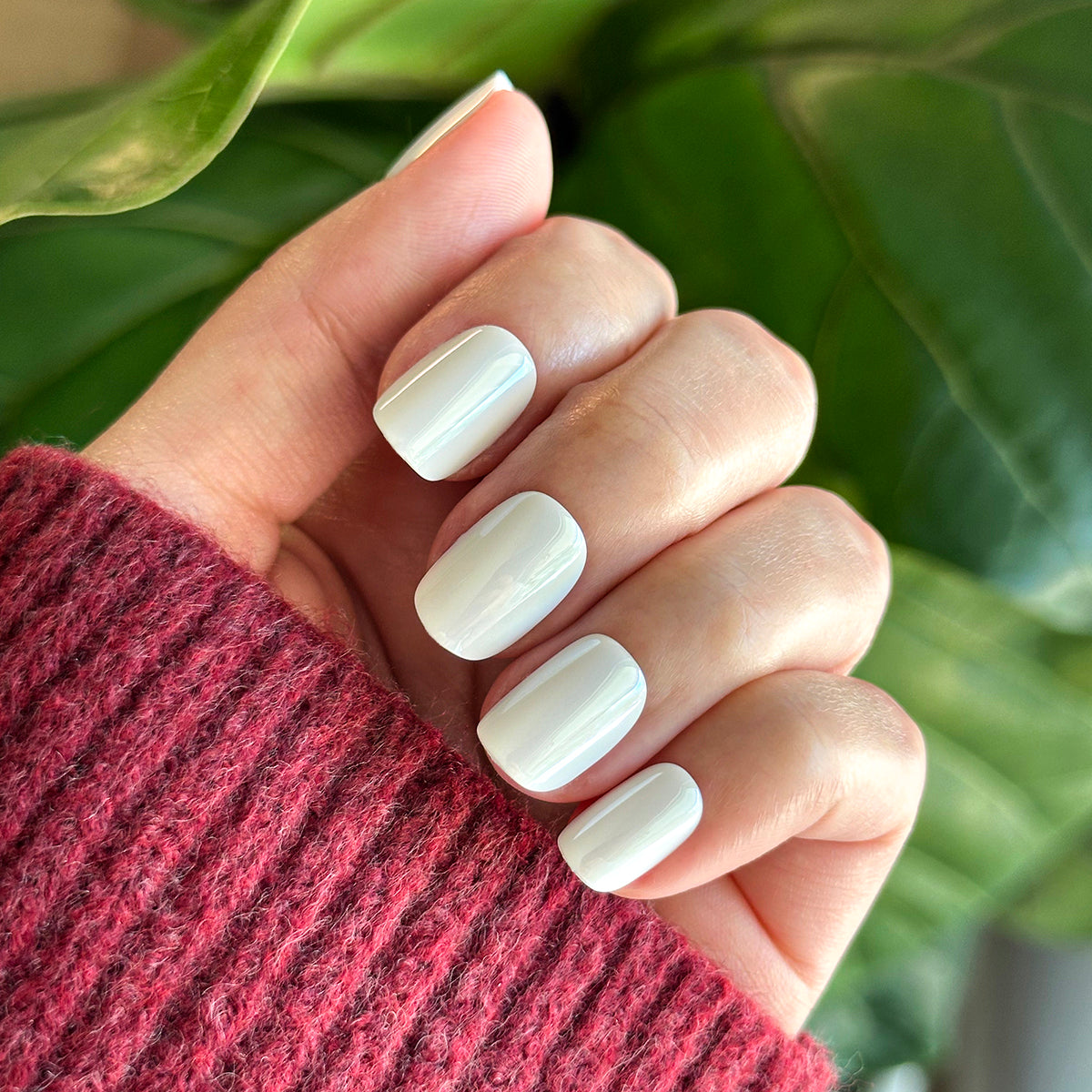 White Chrome - Press-On | Extra Short | Squoval off-white chrome press-on nails shown on hand with cozy red sweater background