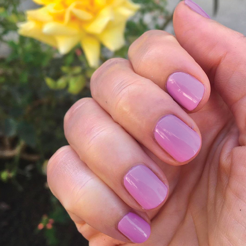 Hand with nails painted in Fierce & Loving lilac gel polish showing a vibrant, long-lasting manicure by Olive and June