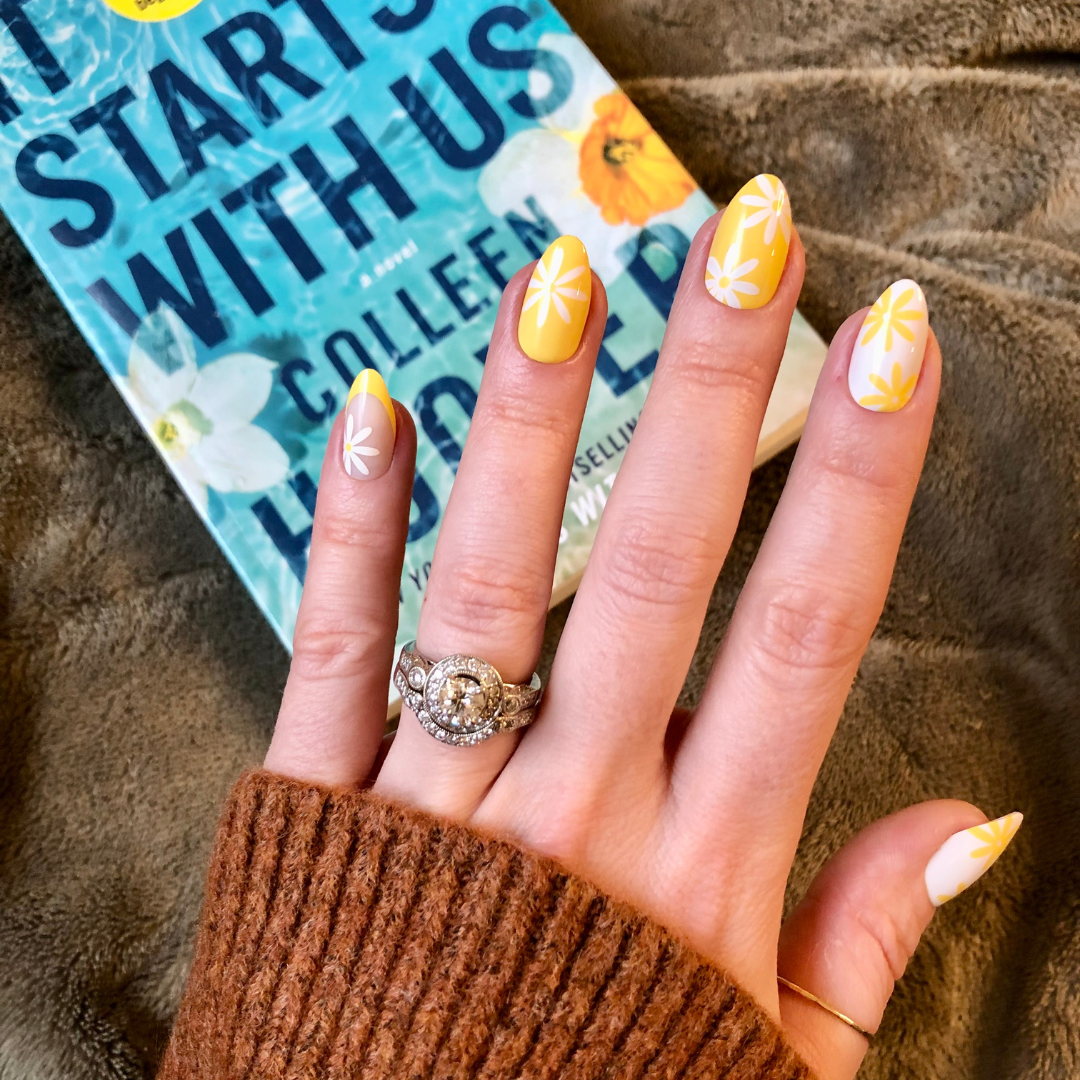 Floral Fun - Press-On | Medium | Almond showing hand with yellow and white floral false nails holding book titled Start With Us