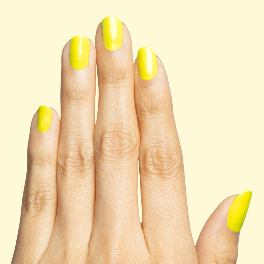 Hand displaying nails painted in bright electric yellow Game Set Mani polish for a vibrant at-home manicure look