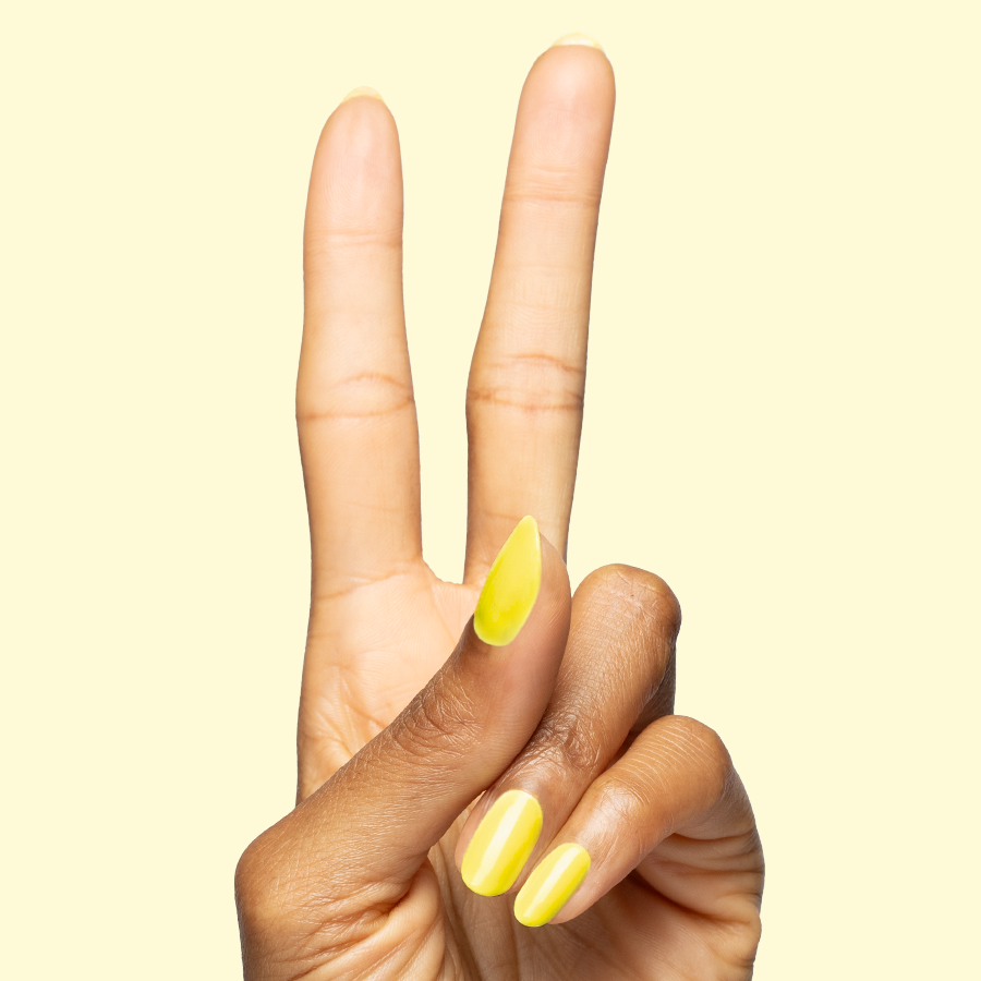 Hand showing two fingers painted in bright electric yellow Game Set Mani polish for a vibrant quick-dry mani