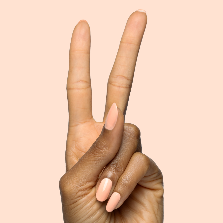 Hand showing elegant nails painted in soft pastel melon shade It’s Serving Melon Cocktails polish for a fresh mani
