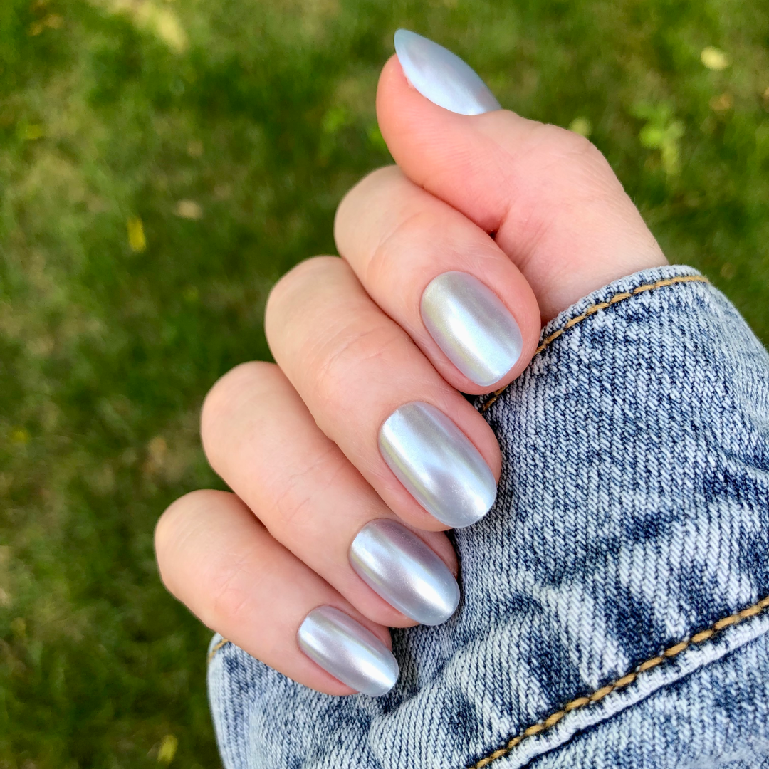 Flew In Love - Press-On | Short | Round showing pale blue chrome short round press-on false nails on hand outdoors