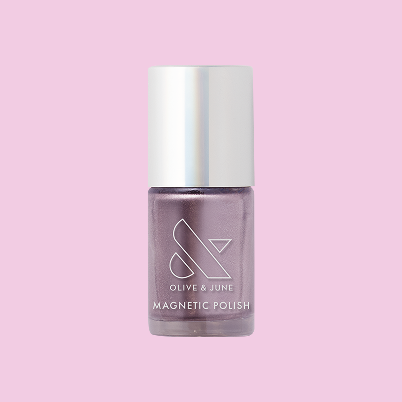 Olive and June Lavender Velvet magnetic polish bottle in frosty purple shade on a pink background for at-home mani.