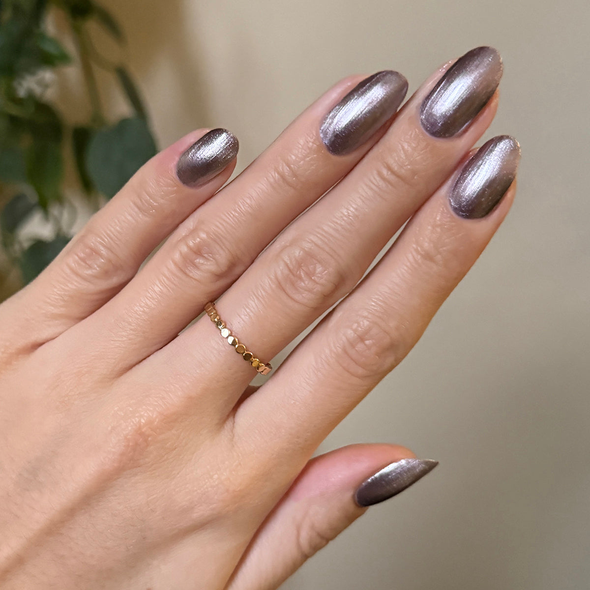 Hand with metallic frosty purple nails polished using Lavender Velvet for a shiny at-home manicure look