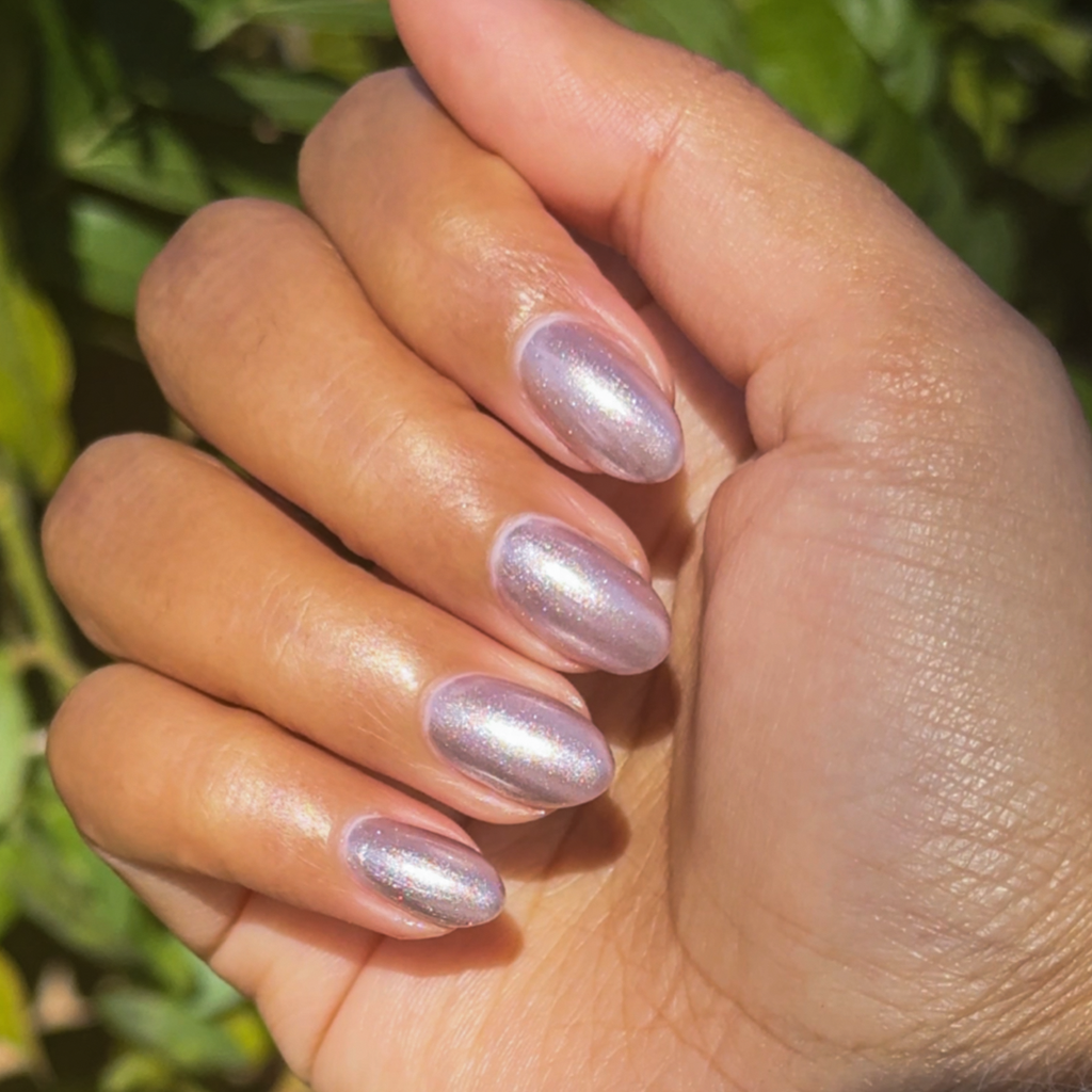 Hand with nails coated in Lavender Velvet frosty purple magnetic polish shown in natural outdoor light