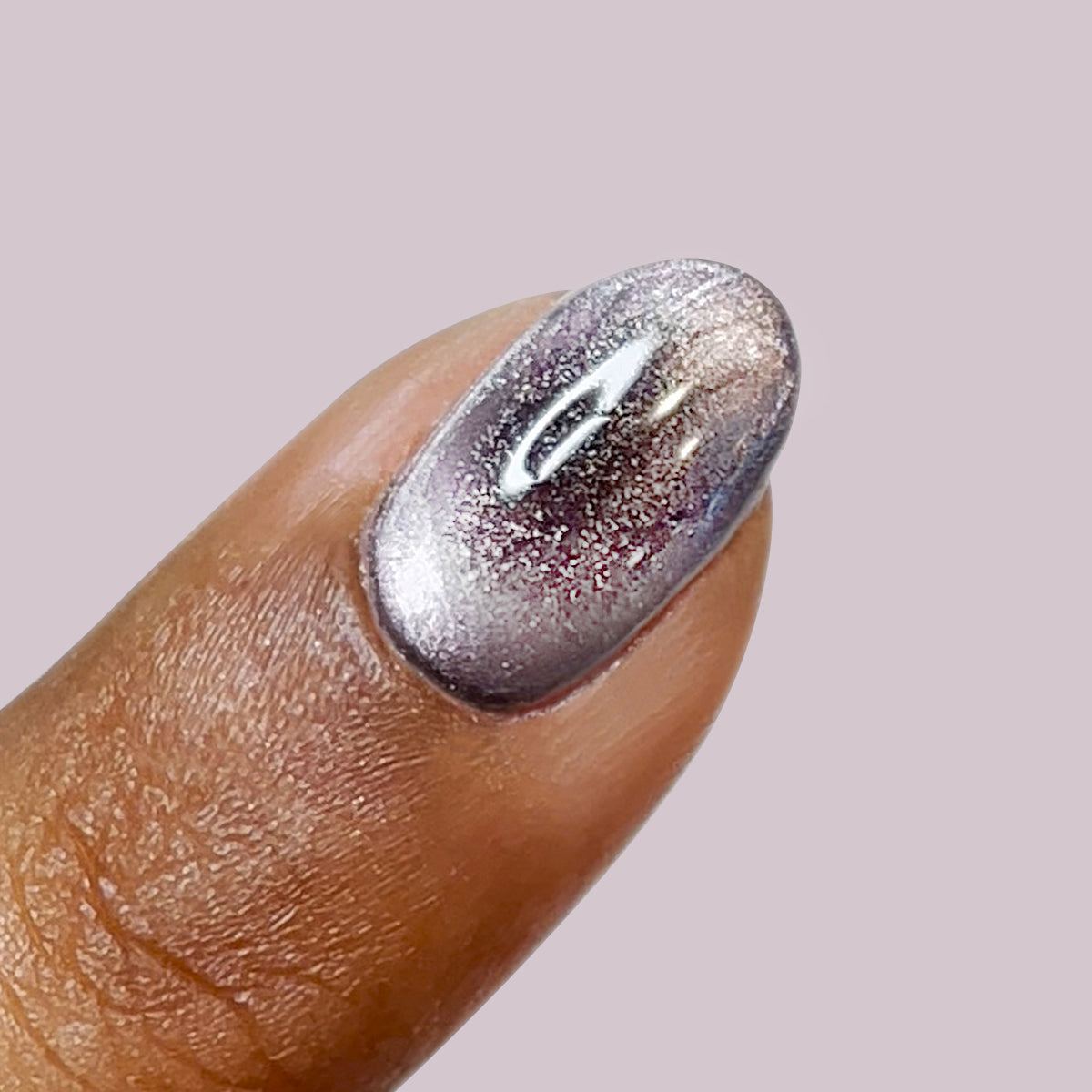 Close-up of a fingernail with Lavender Velvet frosty purple polish showing magnetic shimmer and velvet effect on pale background