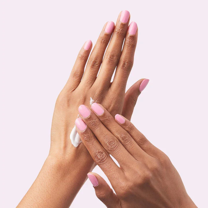 Hands with smooth pink manicure applying Hand Treatment Duo cream for deeply hydrated and renewed skin
