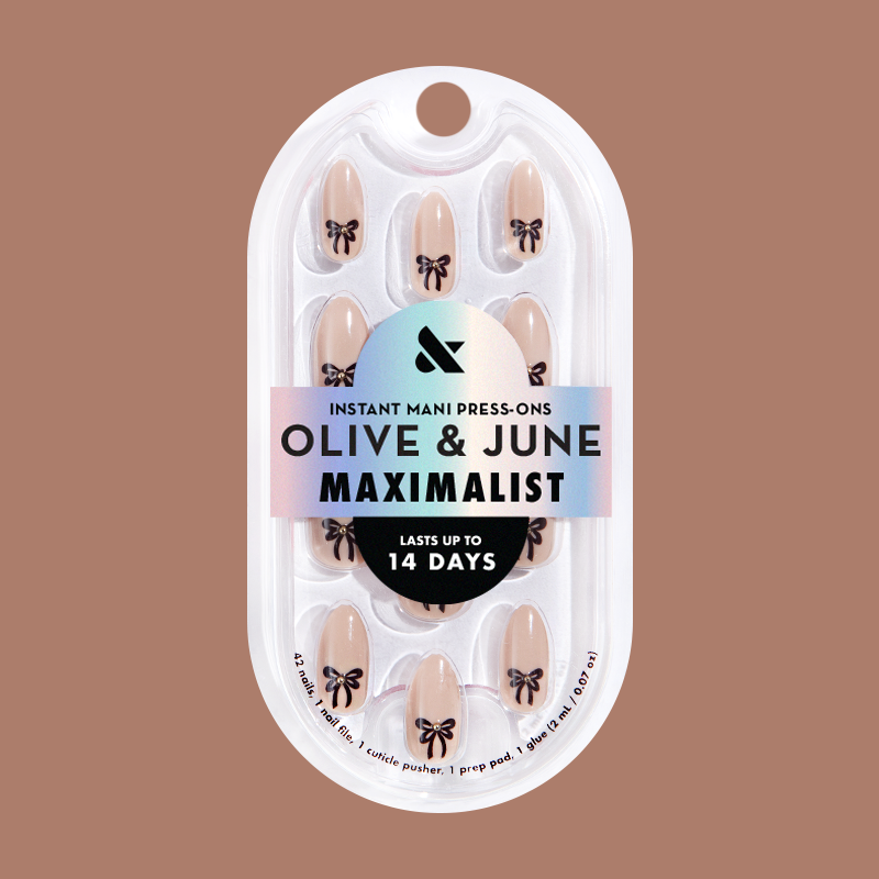 Little Gem Bows - Press On | Medium | Almond creamy beige nails with black bow accents for an easy at-home manicure by Olive and June