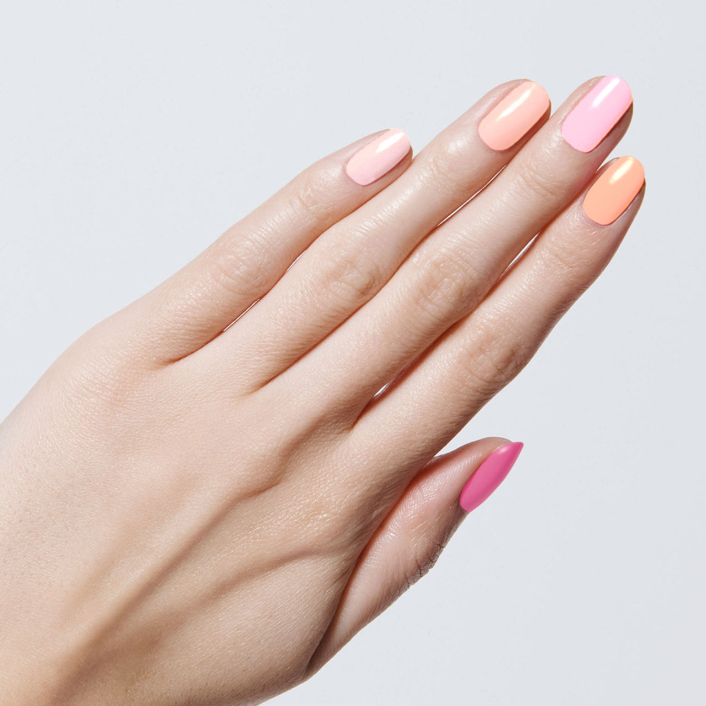 Hand with nails painted in pink and peach shades from the Summer Sorbet Set showing a fresh, long-lasting mani