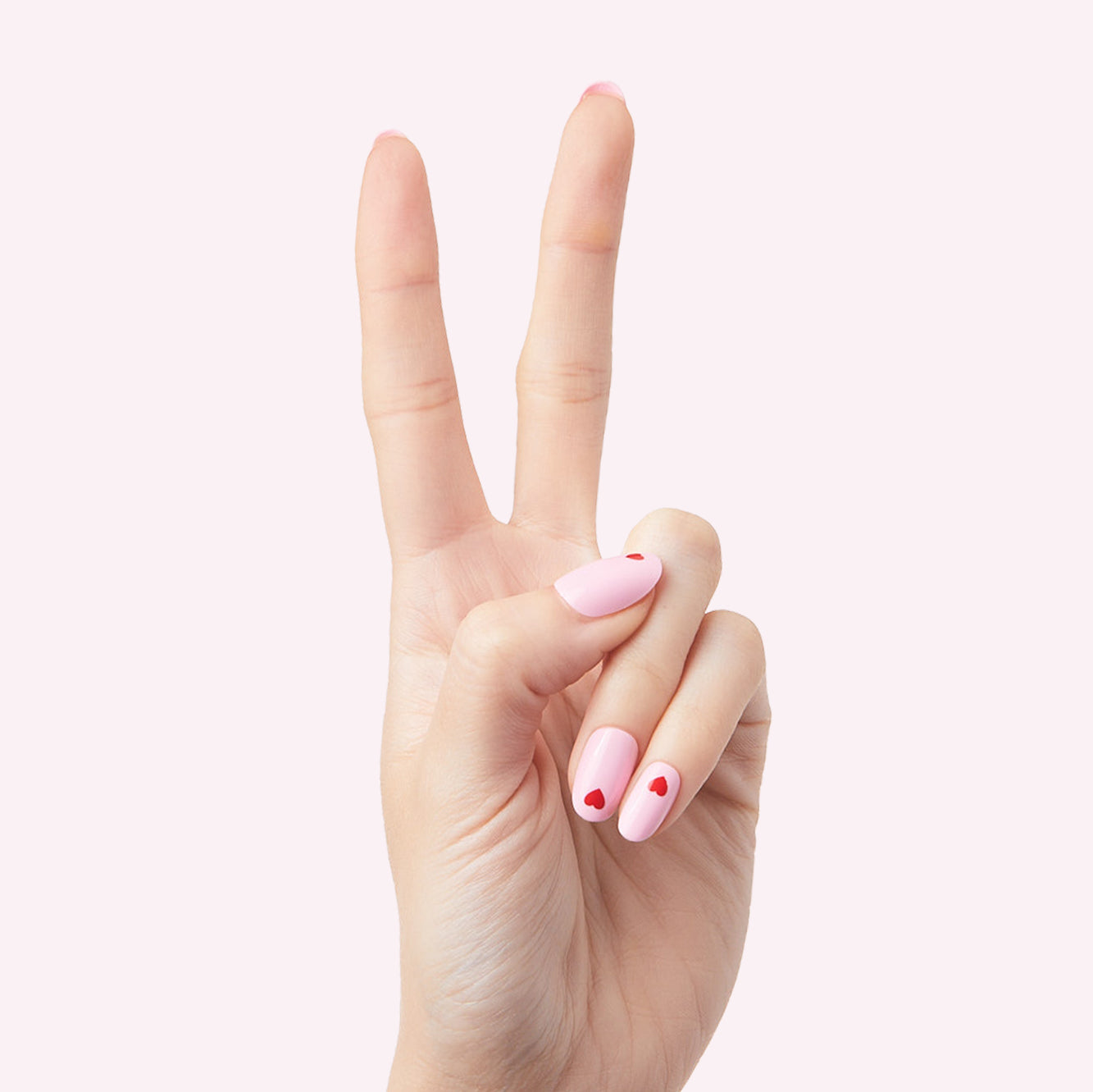 Pink Perfect Heart - Press-On | Round | Short with soft pink base and small red heart design on nails against light pink background
