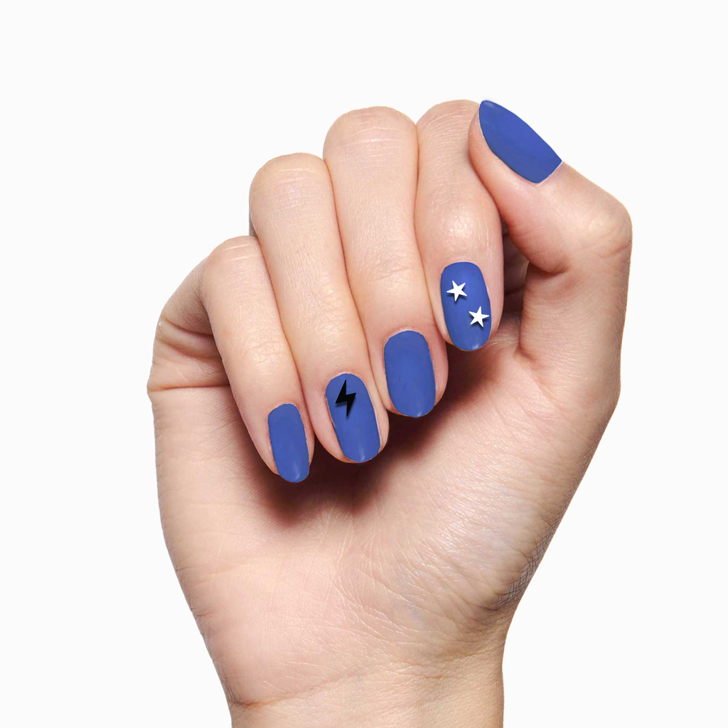 Hand with blue matte manicure featuring EYE LOVE YOUR MANI nail art stickers of stars and lightning bolt designs