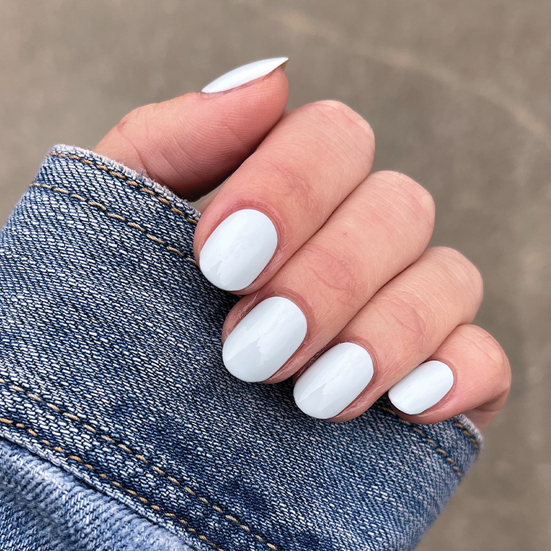 Hand with smooth glossy nails featuring a pale blue Angelfish long-lasting gel polish manicure by Olive and June