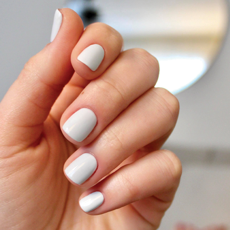 Hand with smooth glossy nails painted in pale icy blue Angelfish gel polish for a clean at-home manicure