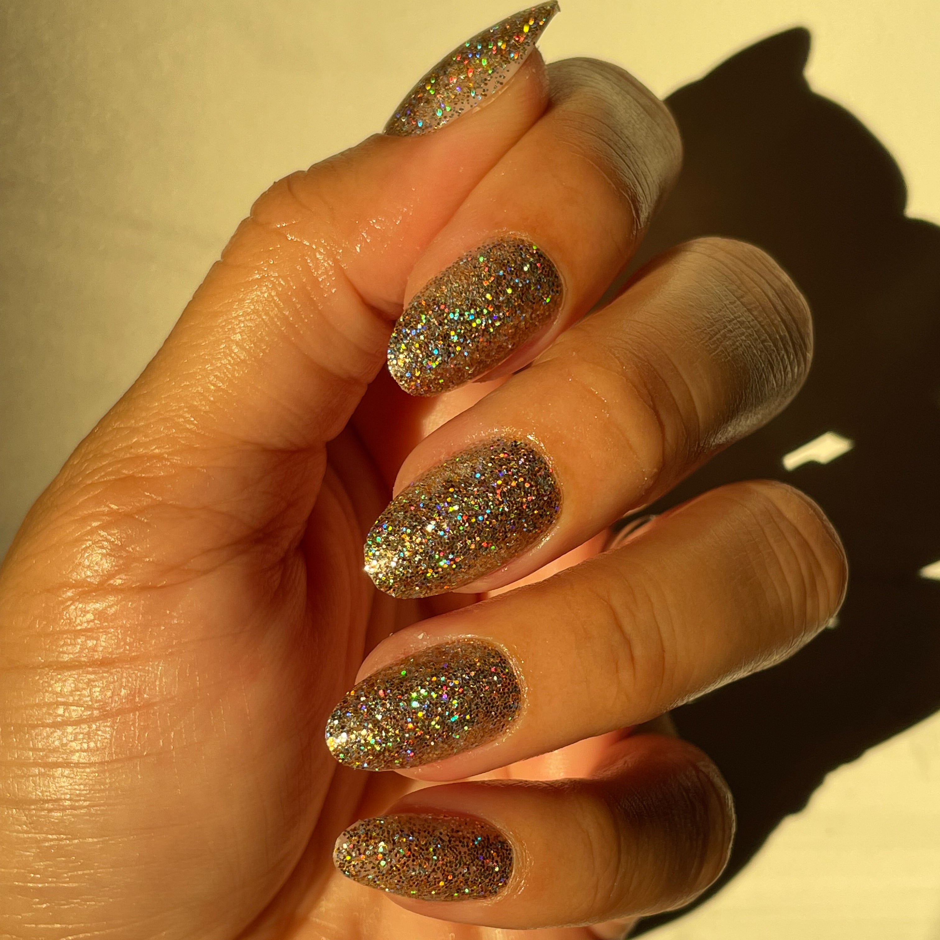 OBVI - Press-On | Medium | Oval hand with medium oval false nails in shimmering gold glitter for a dazzling mani look