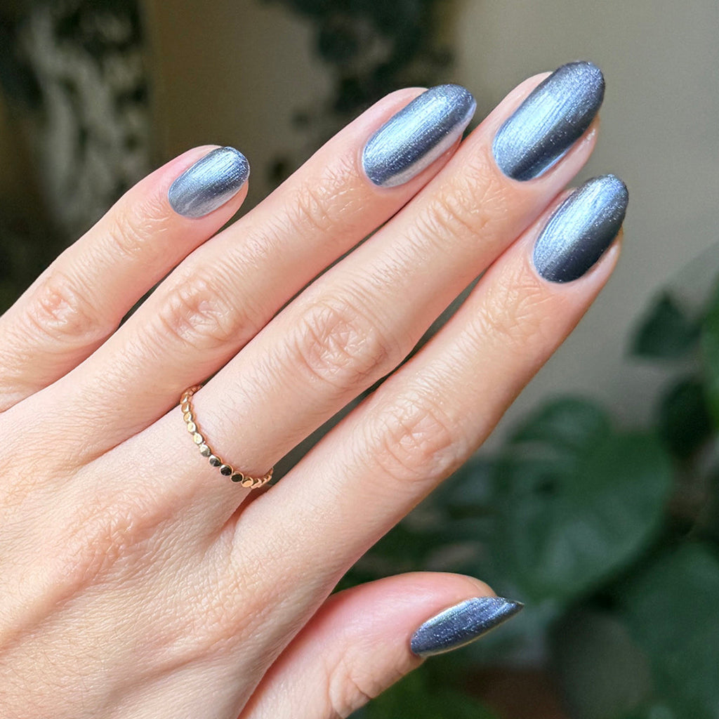 Hand with nails polished in Sapphire Velvet showing icy blue magnetic shimmer for at home manicure look