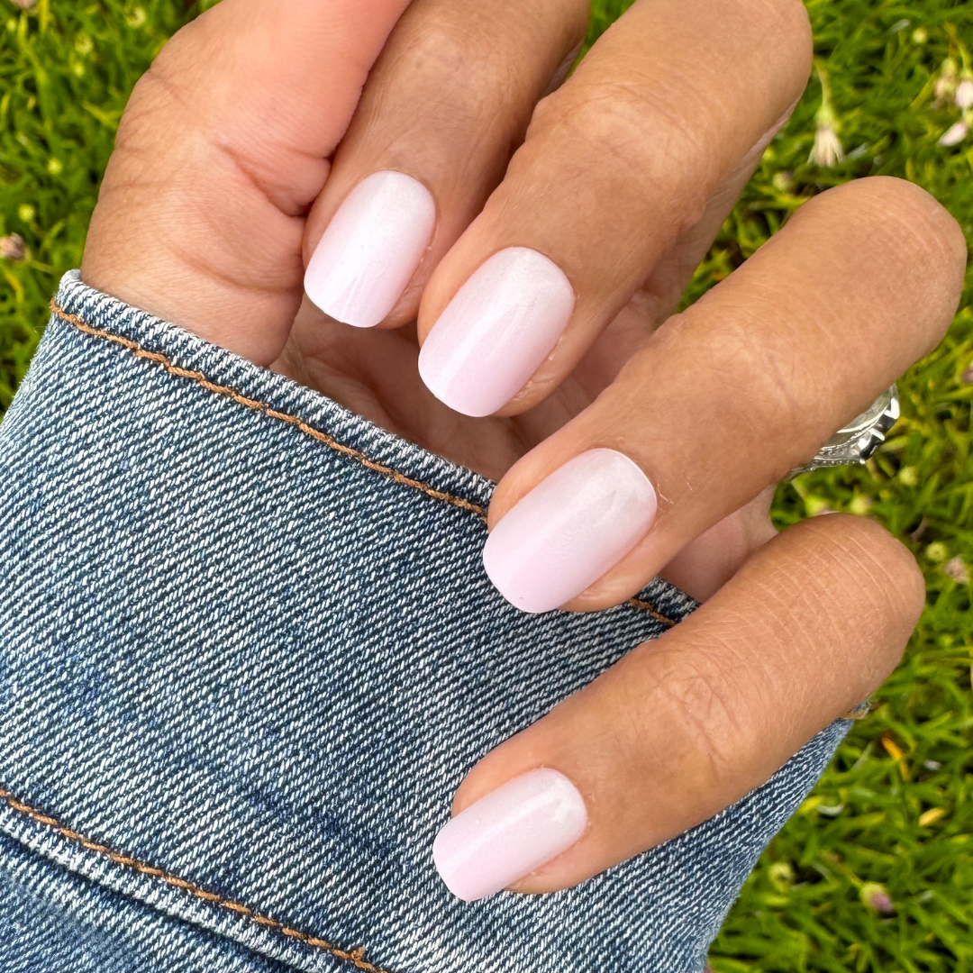 Sheer Pink Gradient - Press-On | Short | Squoval showing hand with short squoval nails in soft cool pink gradient press-on manicure outdoors