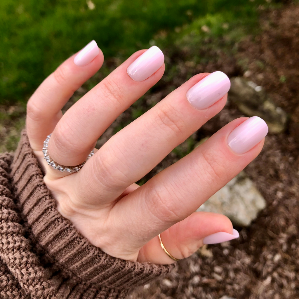 Sheer Pink Gradient - Press-On | Short | Squoval showing hand with short squoval nails in soft cool pink gradient press-on manicure outdoors