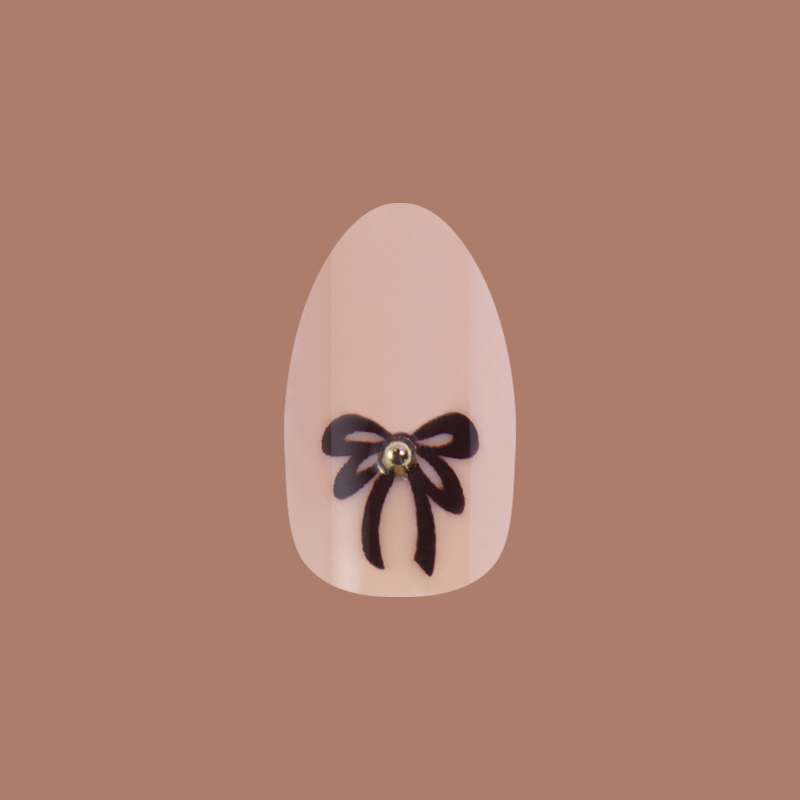 Little Gem Bows - Press On | Medium | Almond nail with creamy beige base and black bow with a 3D gem for an at-home mani